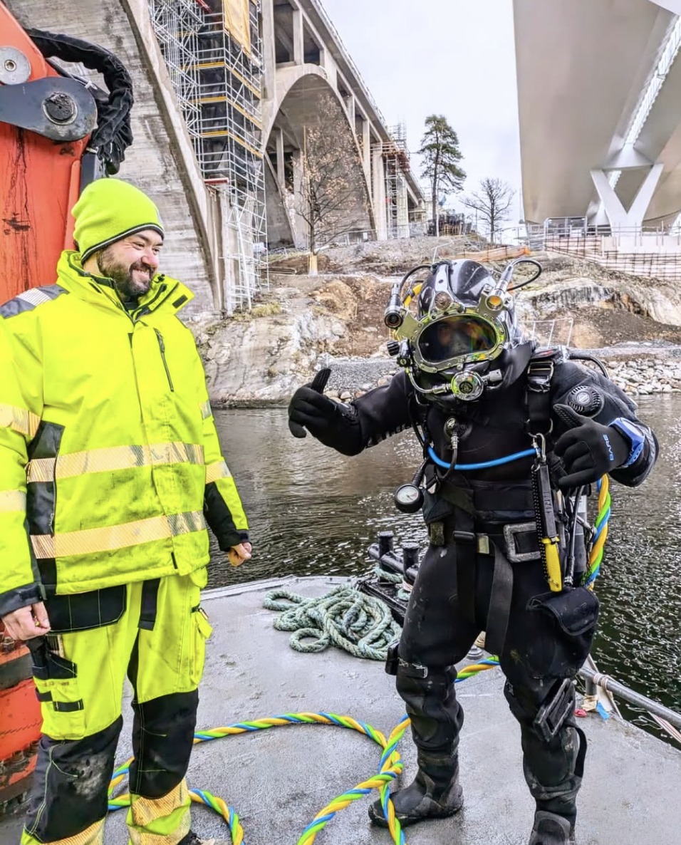 Anläggningsdykare som gör tummen upp på land